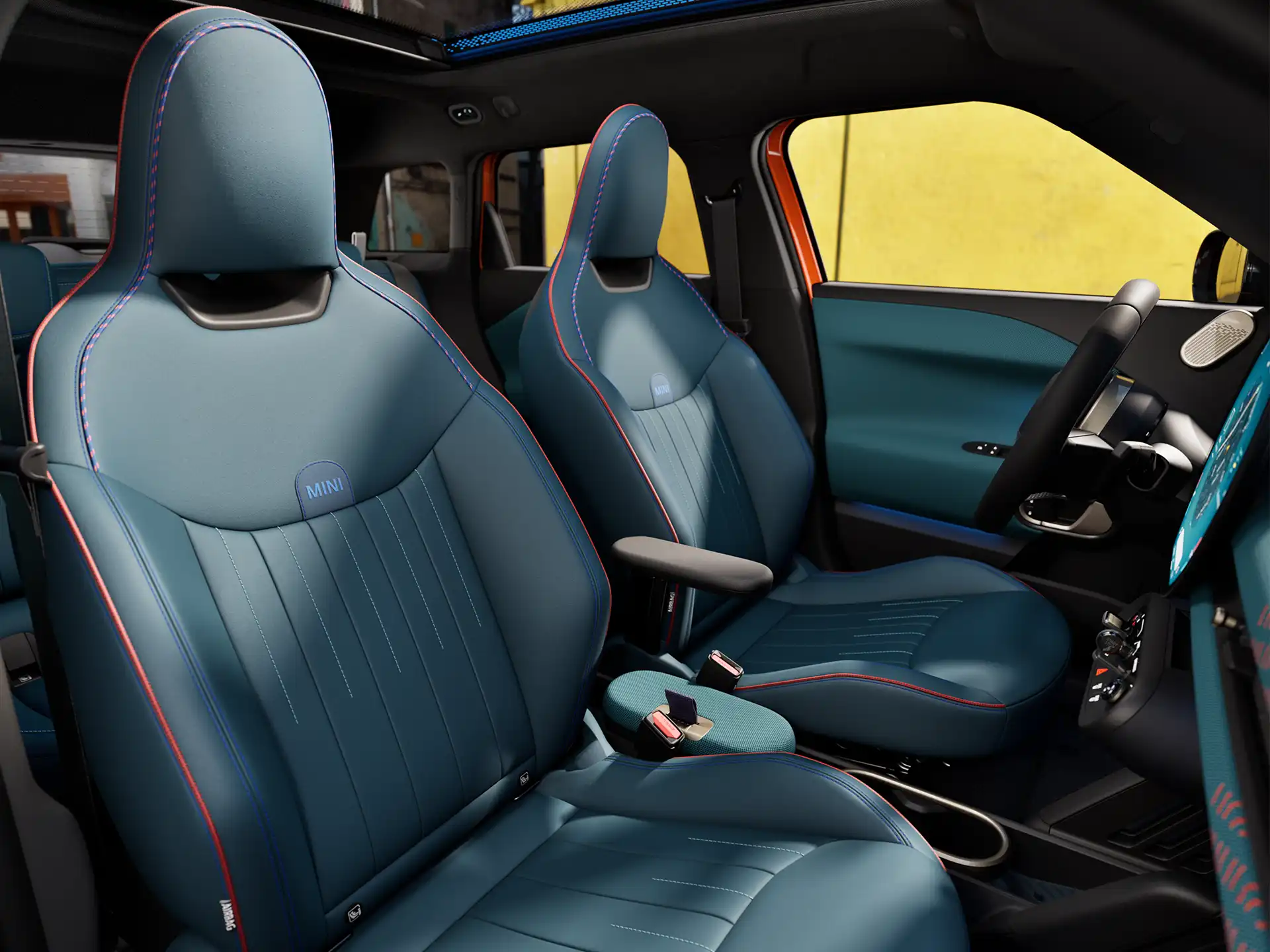 A perspectiva interna do MINI Aceman totalmente elétrico mostra o painel, o volante, o display redondo, o teto panorâmico de vidro e a parte traseira dos assentos dianteiros.
