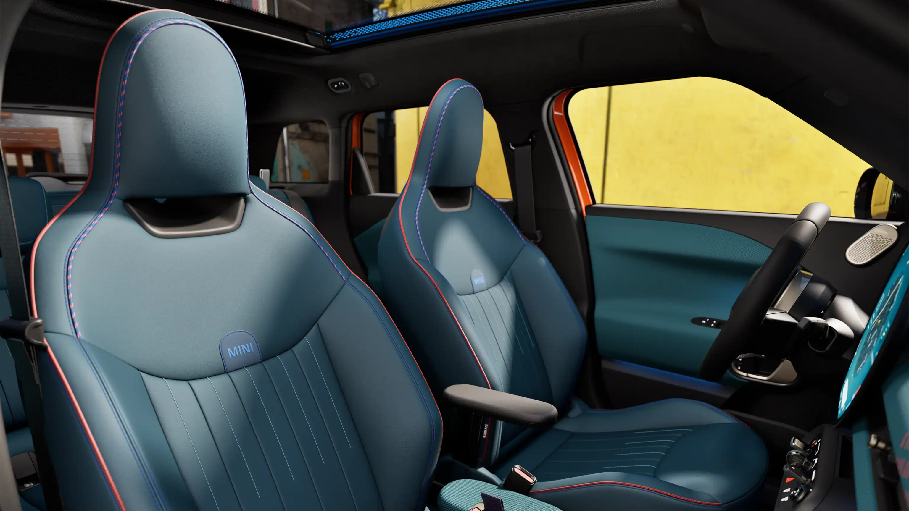 A perspectiva interna do MINI Aceman totalmente elétrico mostra o painel, o volante, o display redondo, o teto panorâmico de vidro e a parte traseira dos assentos dianteiros.