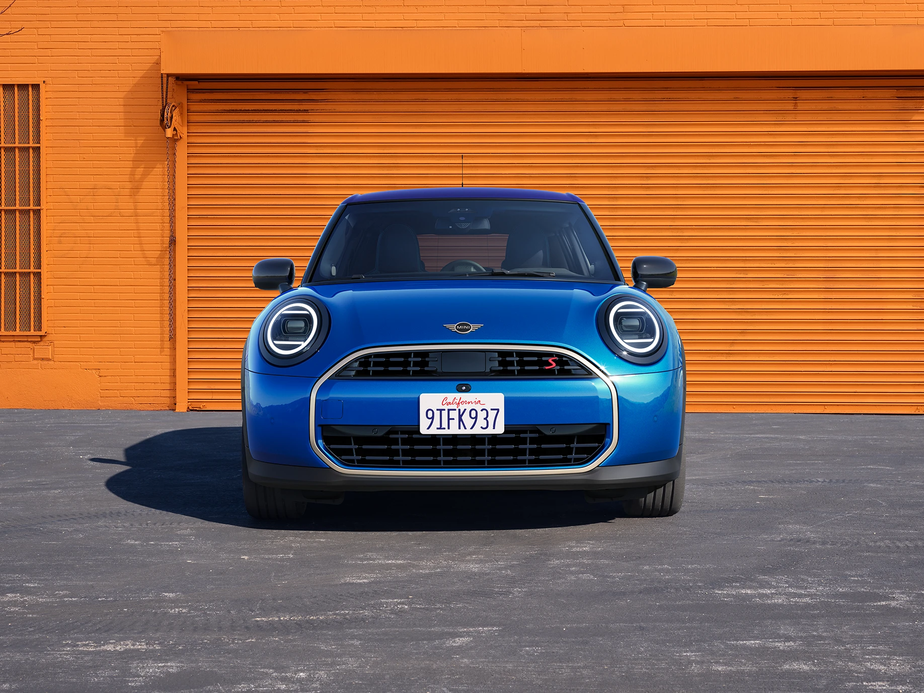 Vista frontal do MINI Cooper 5 portas na cor Icy Sunshine Blue com teto Multitone Blue.