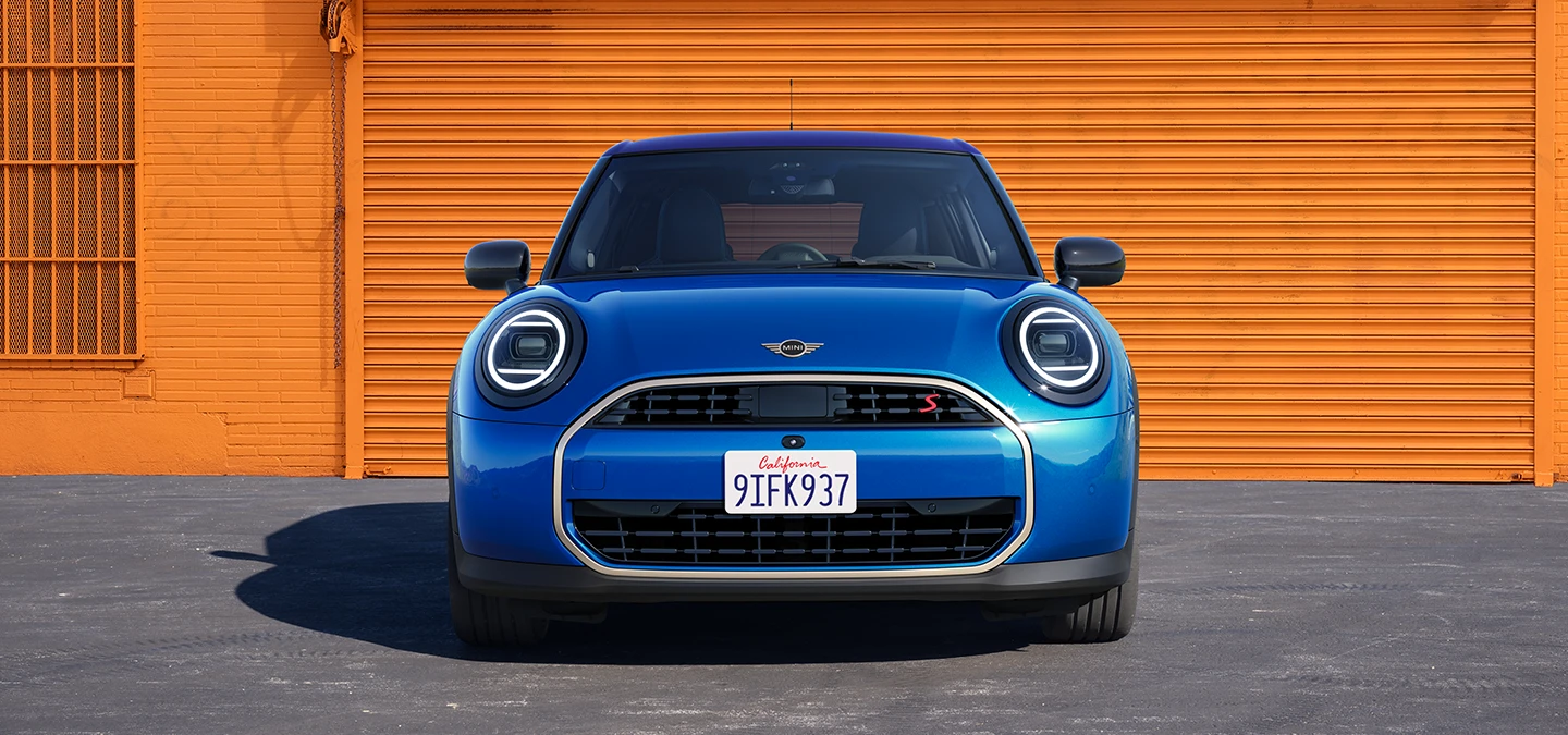 Vista frontal do MINI Cooper 5 portas na cor Icy Sunshine Blue com teto Multitone Blue.