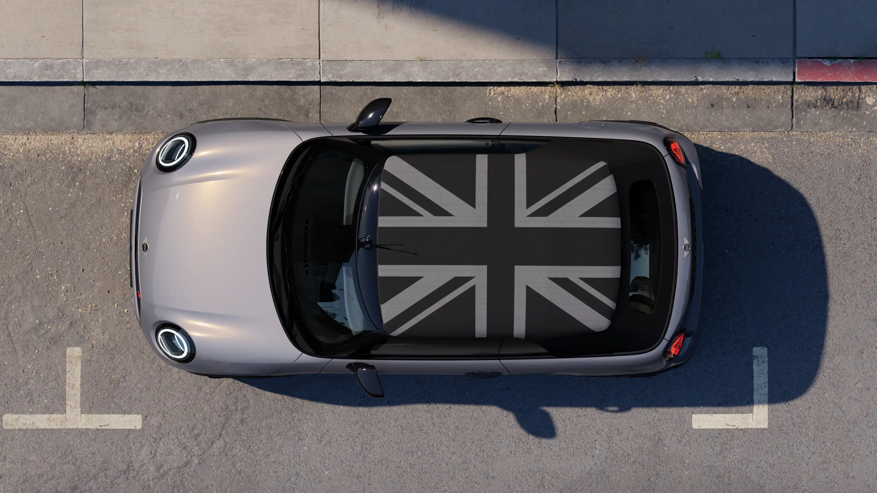 Vista aérea do MINI Cooper conversível em Copper Grey com a capota MINI Yours estacionado na rua.