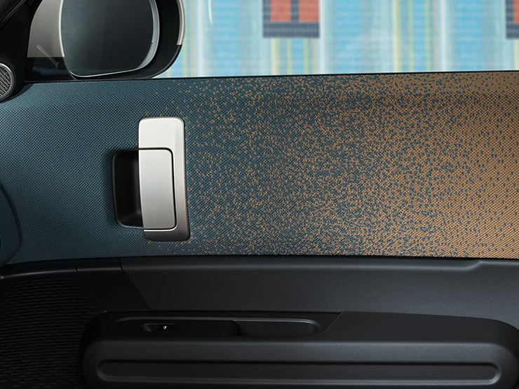 Close-up do design interior do MINI Countryman totalmente elétrico, com foco na porta e no painel de instrumentos.