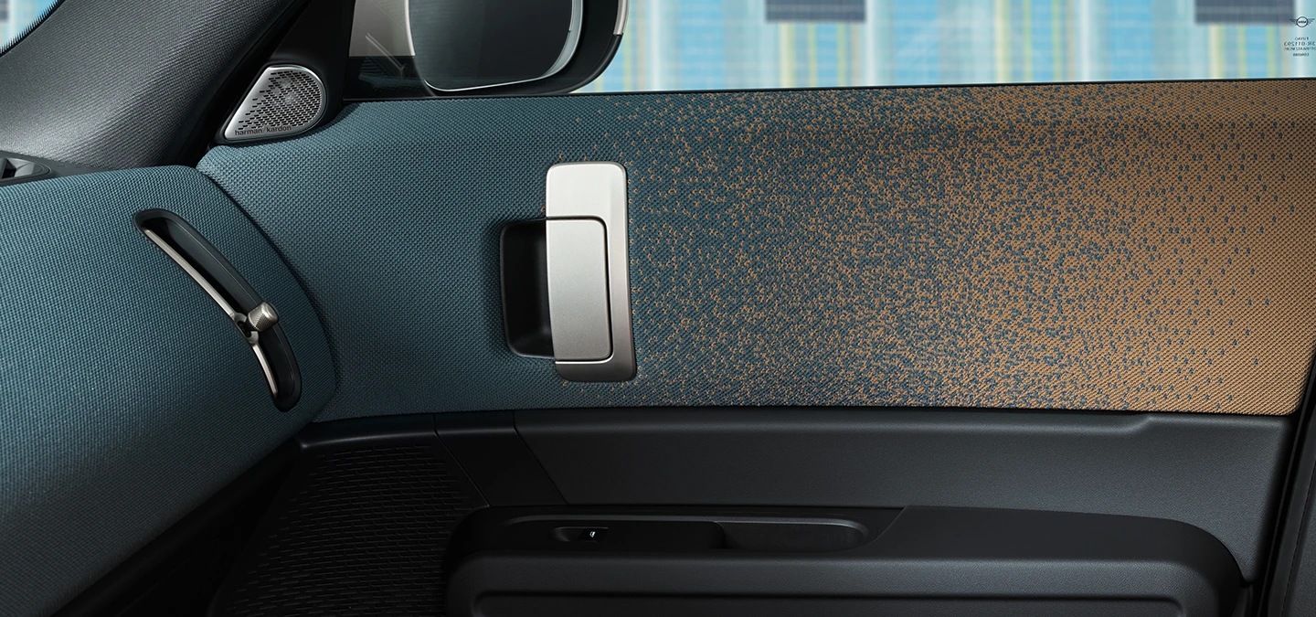 Close-up do design interior do MINI Countryman totalmente elétrico, com foco na porta e no painel de instrumentos.