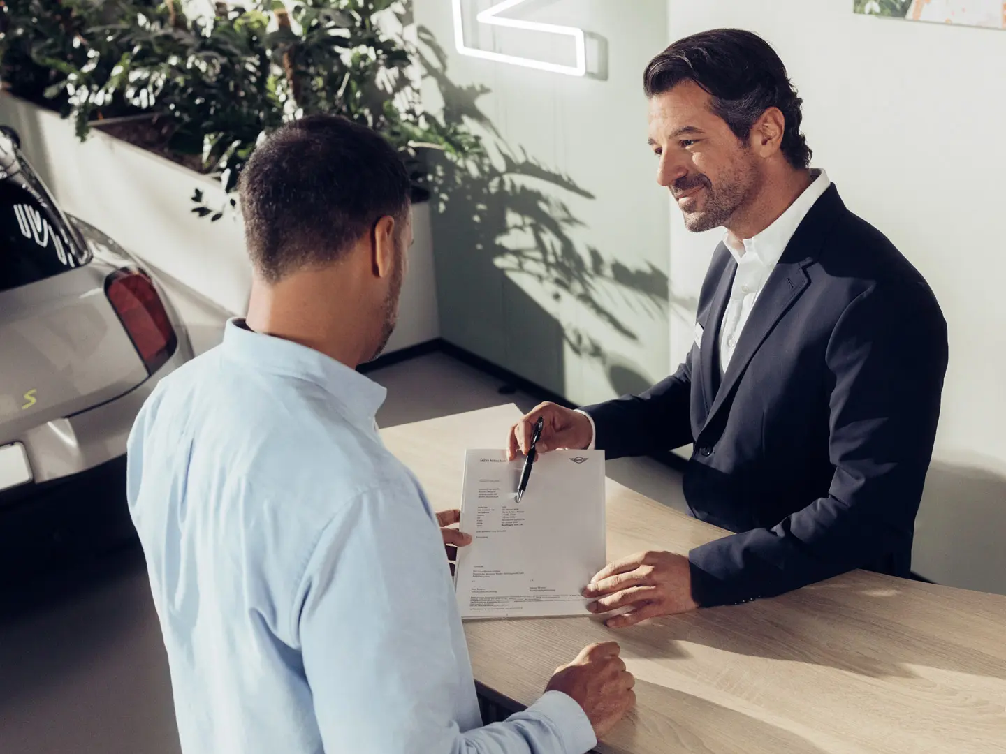 Um assistente de serviço MINI orienta um cliente sobre as opções de seguro de pneus MINI.
