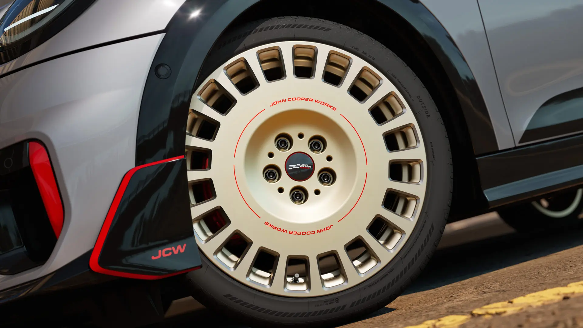 Close-up de uma roda JCW Rallye Spoke 964 de 18'' na cor Vibrant Silver Bicolor com acabamento diamantado e aleta dianteira.