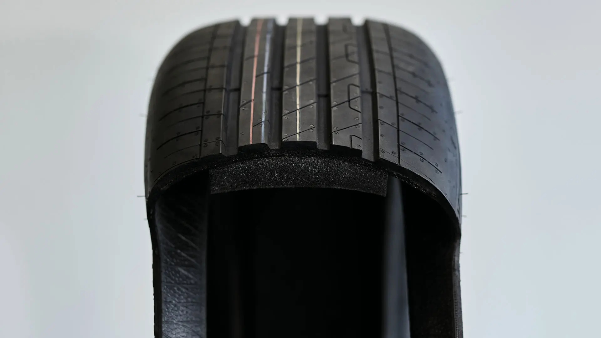 Vista em corte de um pneu run-flat mostrando a parede lateral espessa e resistente, que suporta o peso do veículo após um furo.