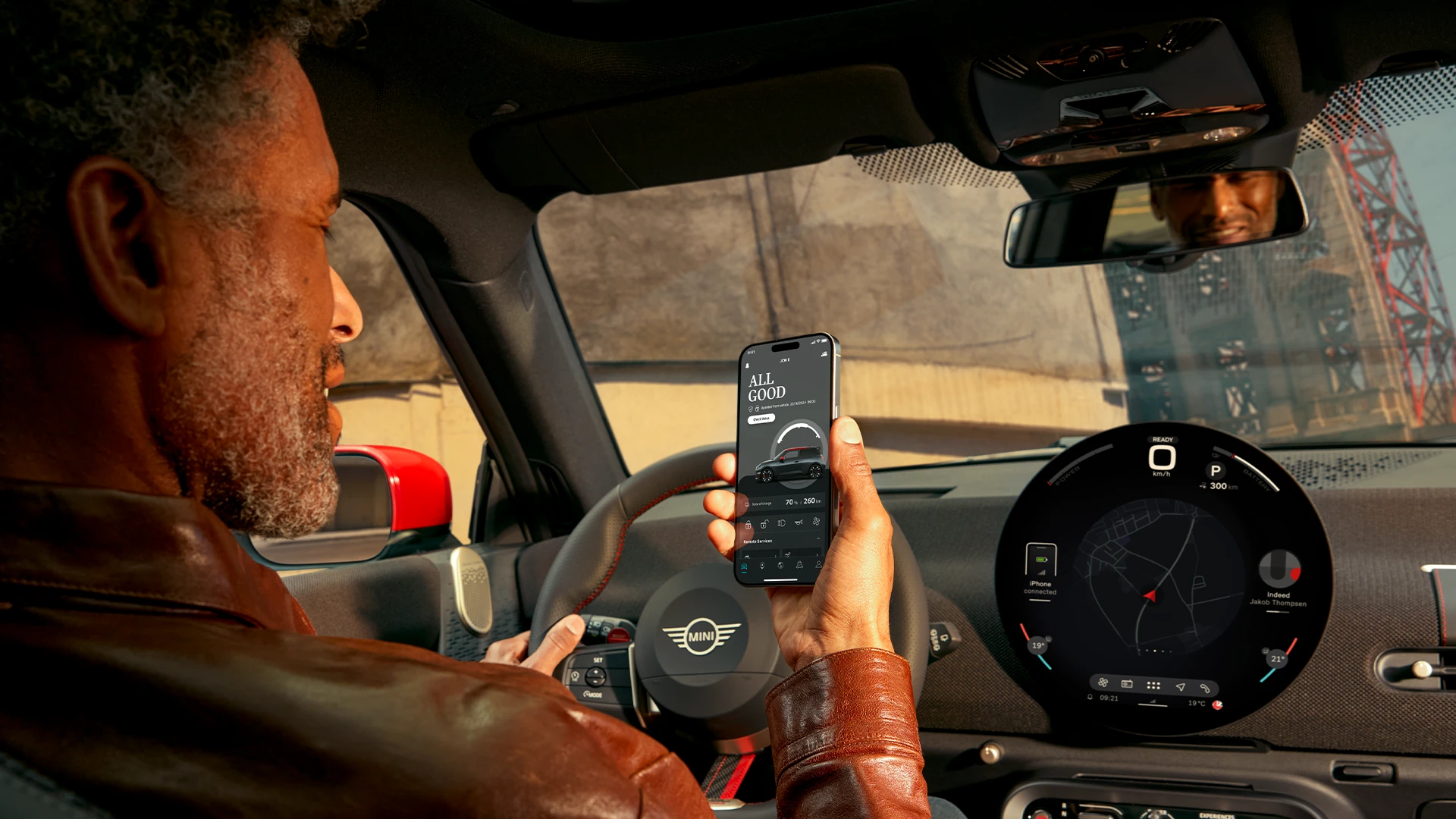 Motorista MINI utilizando o MINI App em seu smartphone para serviços de navegação.