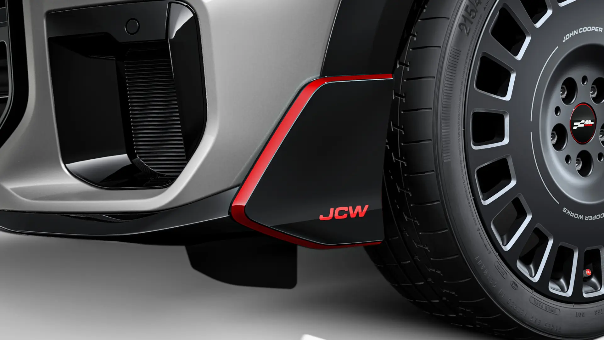 Winglet dianteiro MINI John Cooper Works em preto brilhante com inscrição JCW vermelha e faixas de destaque vermelhas.
